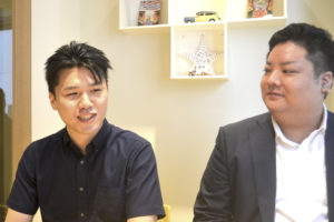 システム開発部の山村孔希さん（左）、社長室・営業企画部課長の迎信義さん（右）